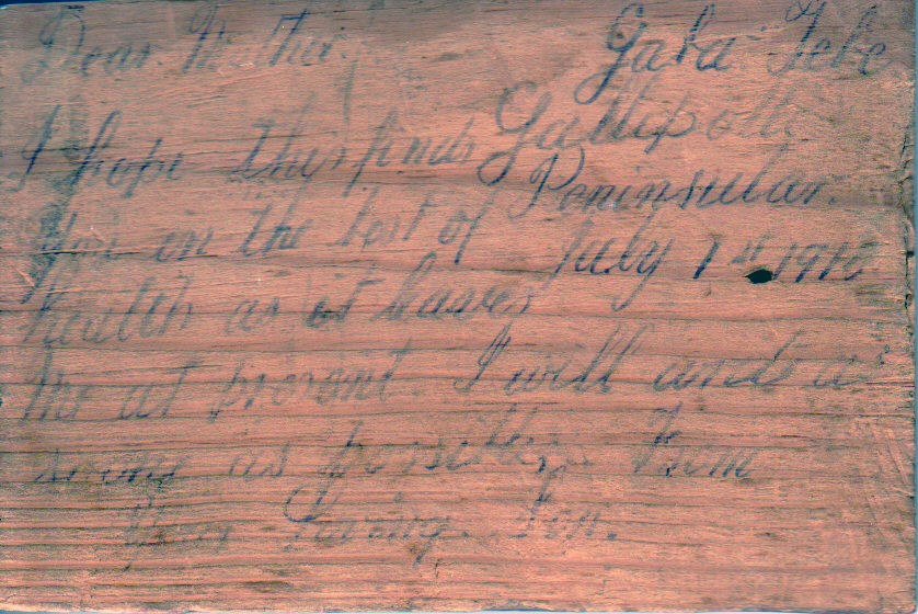 Using a wooden cigar box lid Syd writes a message home to his mum in 1915.