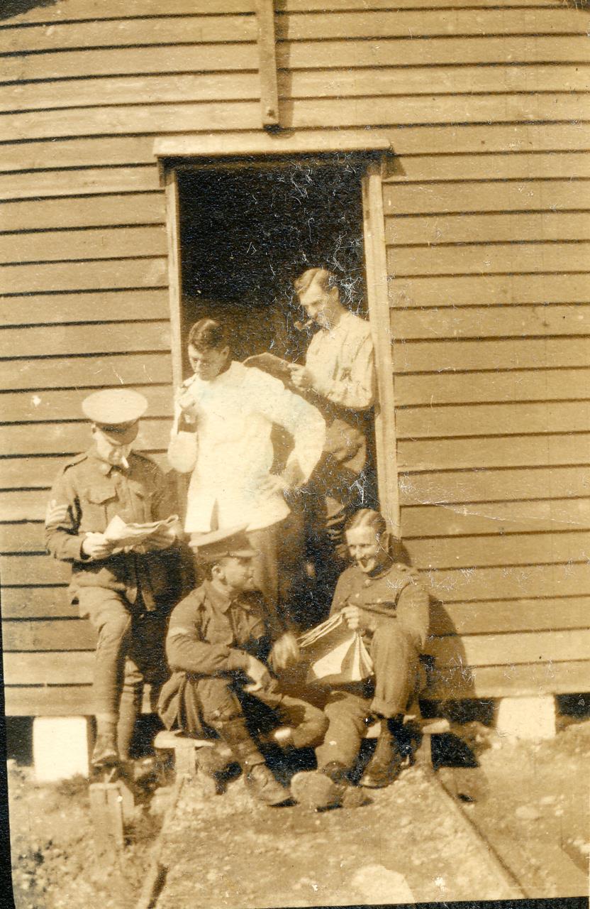 Reg, right, standing in the doorway of a hut at the Chickerell camp.